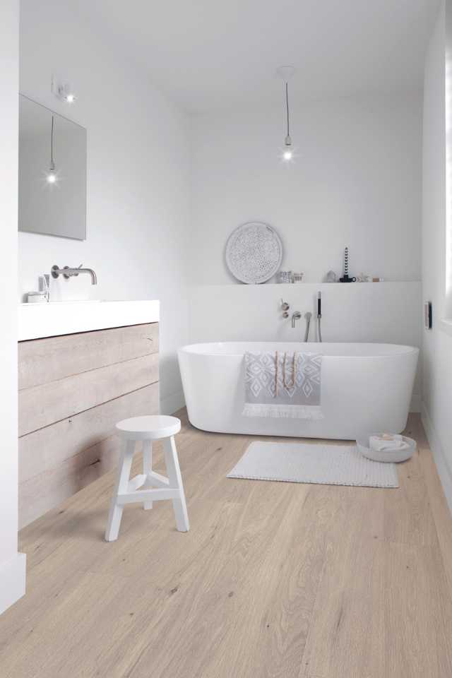 white oak look laminate in all white bathroom with deep soak tub